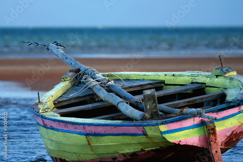 pink yellow sailing boat stranded at low tide in ocean mozambiqu