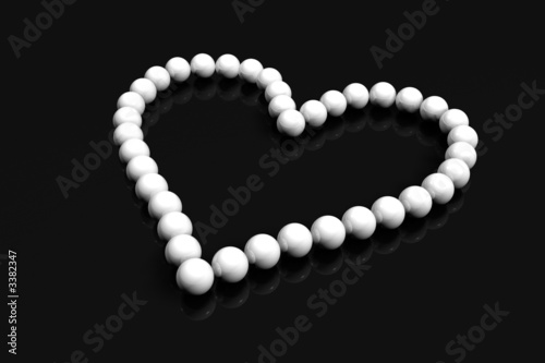 collier coeur perles blanches sur fond noir