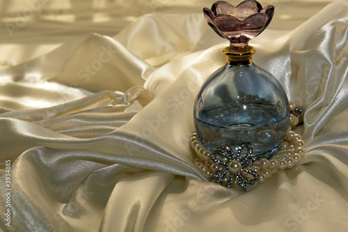 Blue perfume bottle with pearls on satin