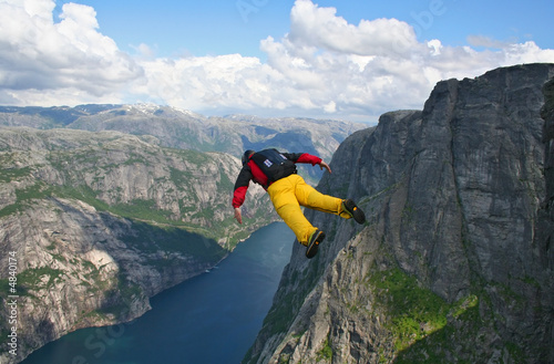 base-jumper falling from cliff down to the fjord