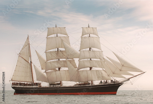 Vintage windjammer style ship with full sails on the open sea