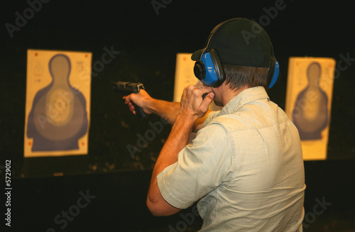 marksman on the range using a flashlight while shooting a pistol