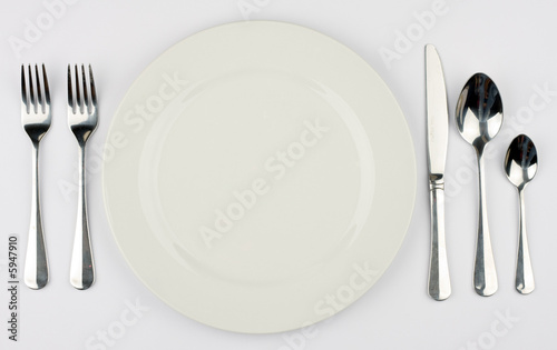 A place setting for a dinner against a white tablecloth