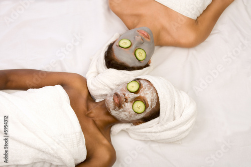 Two girls are relaxing during facial mask application in spa