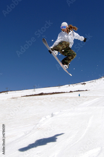 snowboarder in air over snow with tip up grabbing board