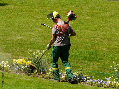 jardinier maniant une tondeuse à essence