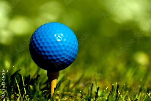 Blue golf ball on wooden tee Focus on ball saturated colors.