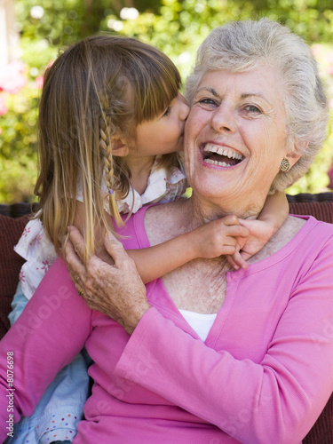 Grandmother getting a kiss from granddaughter