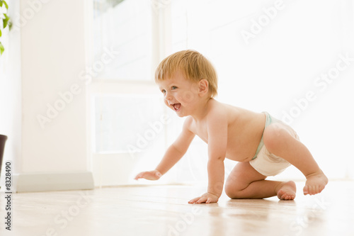 Baby crawling indoors smiling