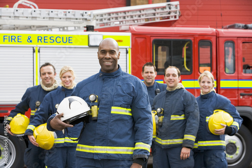 Portrait of a group of firefighters by a fire engine