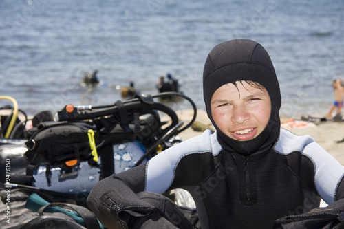 young diver on the sea beach, near scuba gear