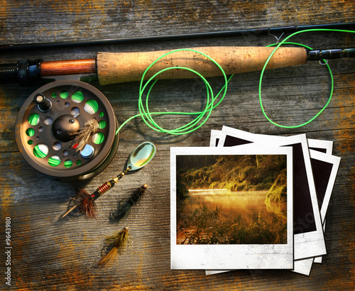 Fly fishing rod with polaroids pictures on wood background