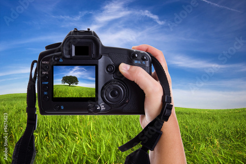 Woman photographing landscape with digital photo camera