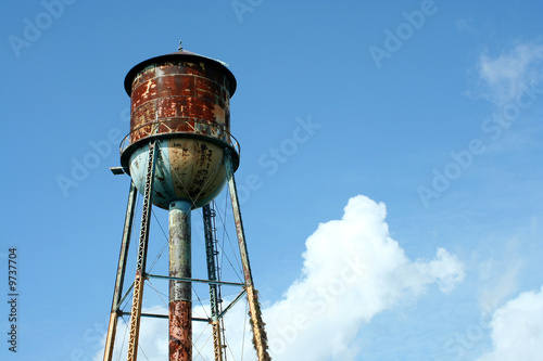A Old rusty watertower against blue sky