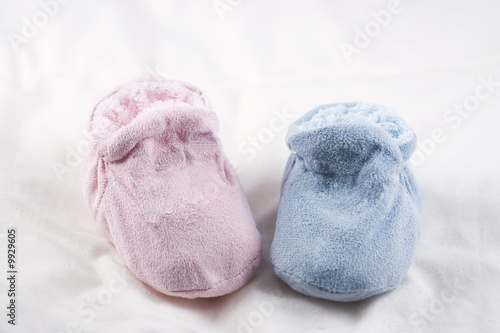A pair of pink and blue baby shoes on a white background.