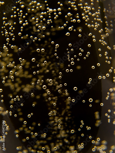 Macro of sparkling champagne against black background.