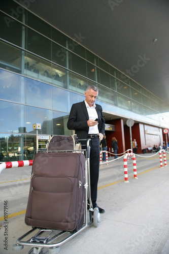 Homme d'affaires attendant un taxi à l'exterieur d'un aéroport
