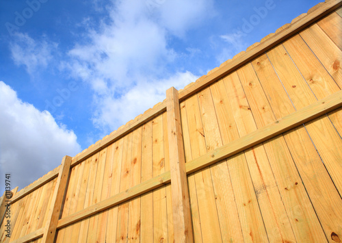 Wooden fence against a cloudy sky