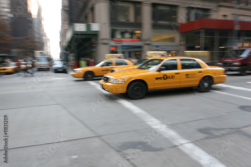 Three fast driving yellow cabs (Taxi car) in Manhattan Soho in New York City, USA