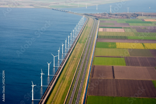 Dutch farmland with windmills along the dike