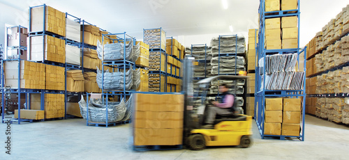 Automotive parts shipping warehouse. A moving forklift moves boxes inside the warehouse