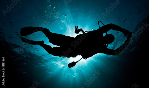 male diver silouette in deep ocean
