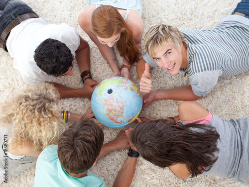 Group of teenagers on the floor examining a terrestrial world an