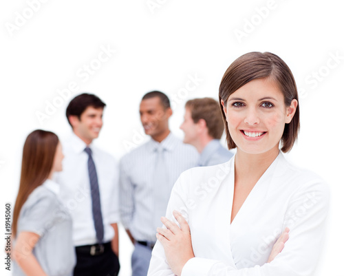 Confident manager in front of her team with folded arms