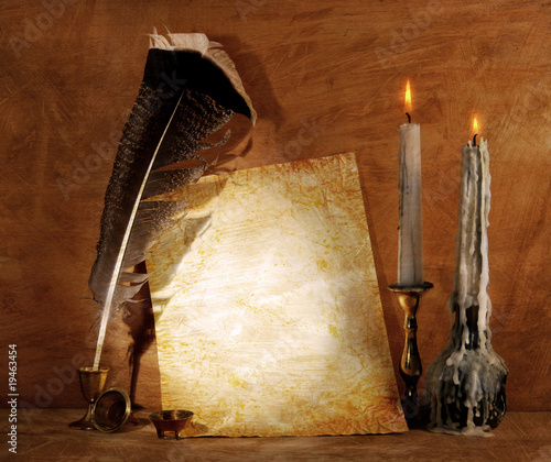 Old paper with a candle and a quill pen.