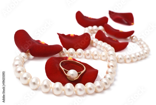 Pearl necklace on red petals