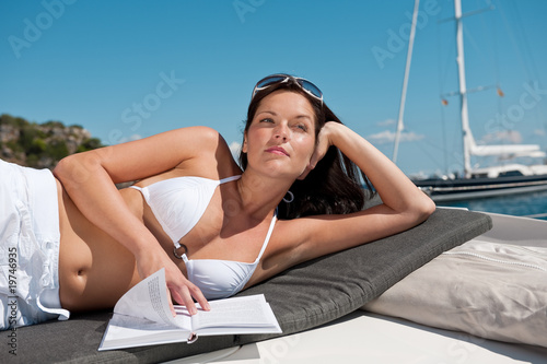 Attractive woman sunbathing on luxury boat