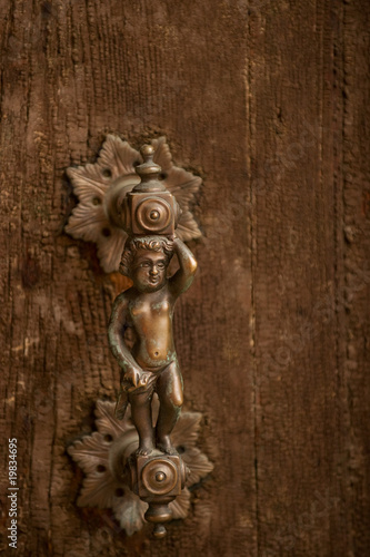 Antique brass knob on wooden door of Venetian palace
