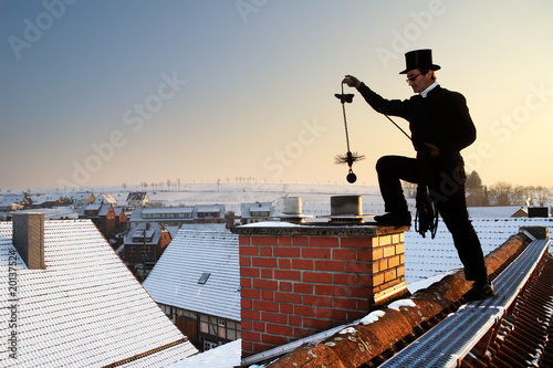 chimney sweep with stovepipe hat upon the roof