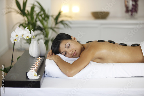 Femme avec des pierres chaudes de massage