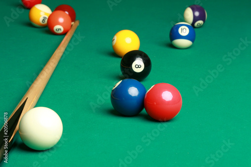 Billard table with a couple of balls and cue