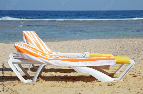 two chaise-longues with towels on beach