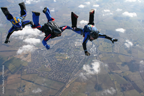 Three skydivers form a line behind each other