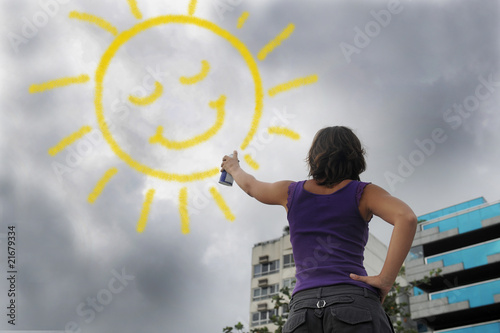 woman painting the sun onto the cloudy sky