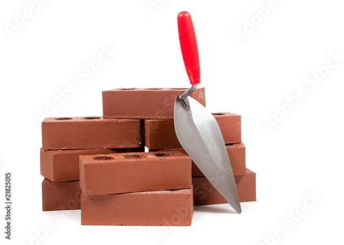 Bricks and a trowel on white