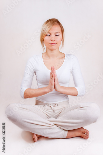 young woman practicing yoga (hands together) separated on white