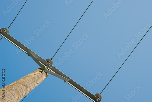 Electric wires and wooden pole on blue sky