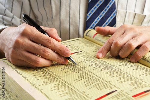 Businessman searching in yellow pages