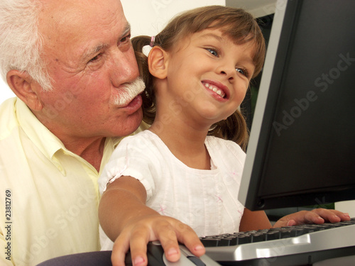 Abuelo y nieta en una computadora.