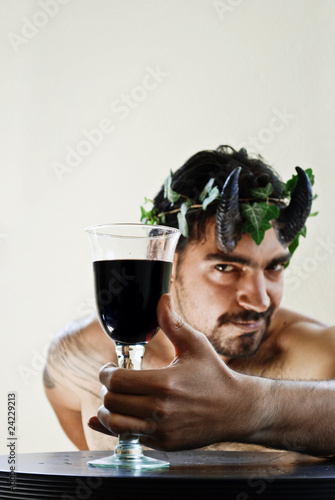 A satyr is offering a glass of red wine
