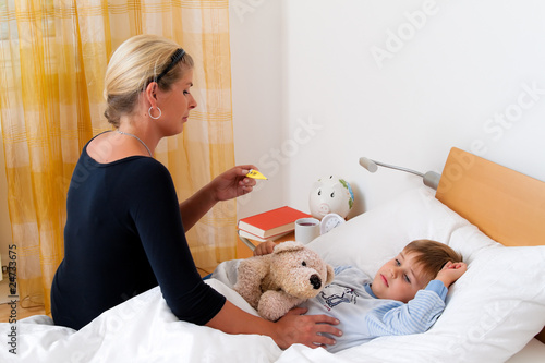 Mutter und krankes Kind im Bett. Grippe. Kinderkrankheiten.