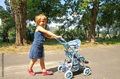 A little girl with toy carriage