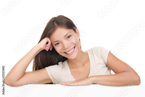 Woman leaning on blank white billboard sign