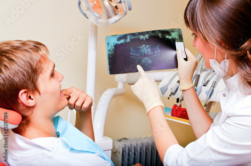 Dentist explaining the details of a x-ray picture to her patient
