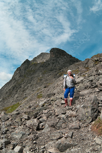 Backpacker a young woman climbing in mountain