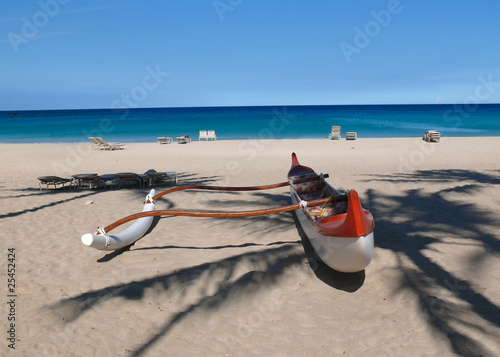 Red and white outrigger at peopleless Kauna'oa Beach, Hawaii